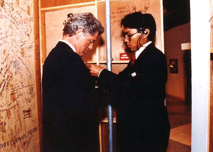 A Local 54 crew member adjusting President Clinton's microphone in 1994.